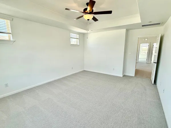 an empty room with windows and fan