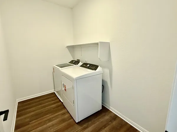 a utility room with wooden floor washer and dryer