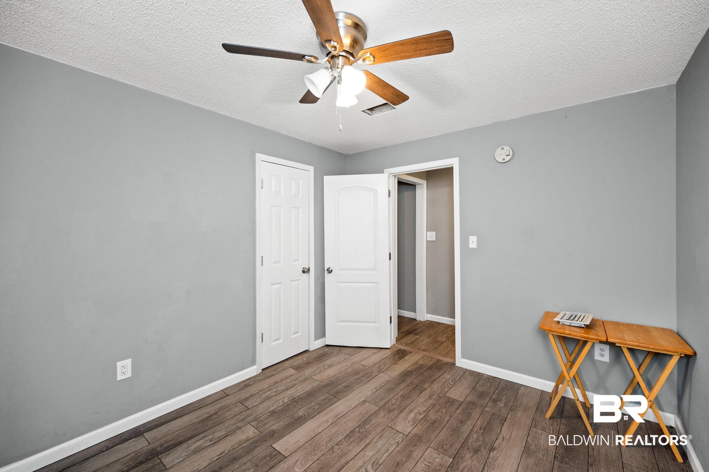 906 North Cedar Street Foley, AL 36535 - Photo 13 of 24 Bedroom with ceiling fan, a textured ceiling, and dark hardwood / wood-style flooring