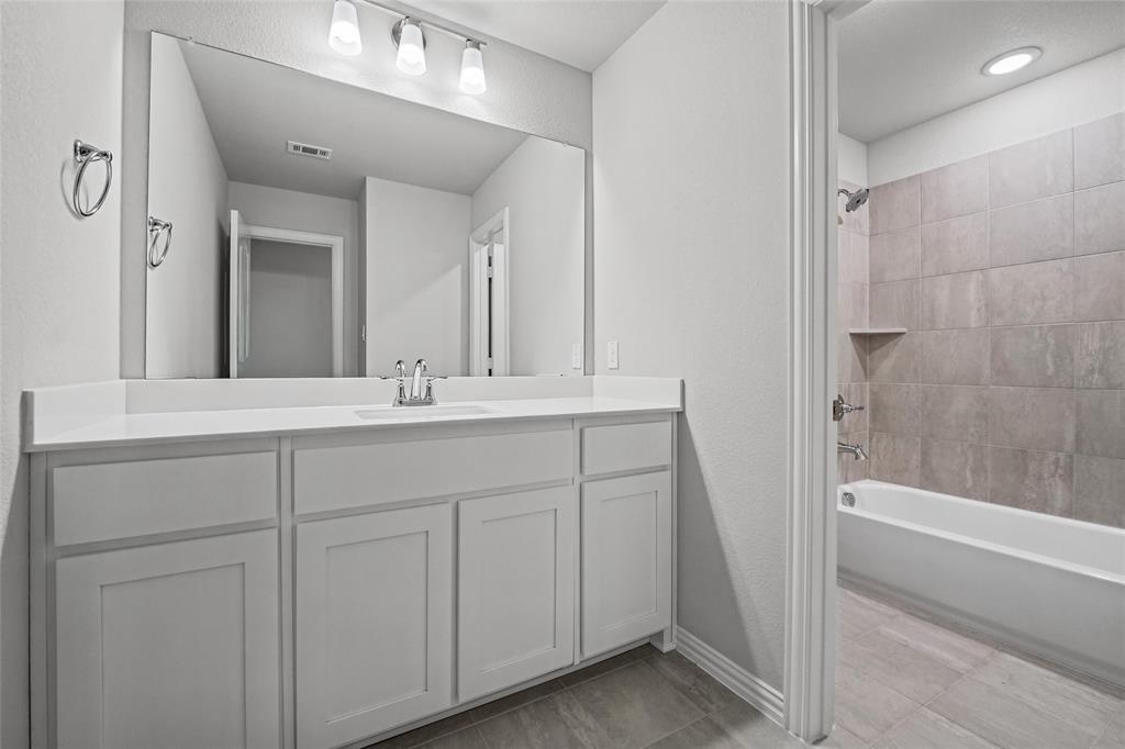 1205 Colca Drive Springtown, TX 76082 - Photo 30 of 37 Vanity with integrated sink and chrome faucet, large rectangular mirror, and overhead track lighting
