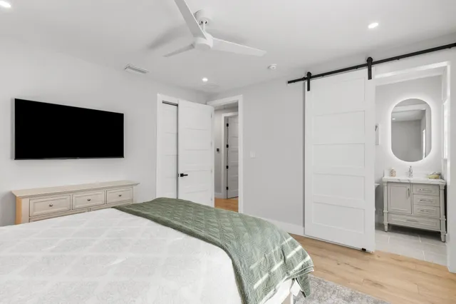 a bedroom with a bed and a flat tv screen on wall