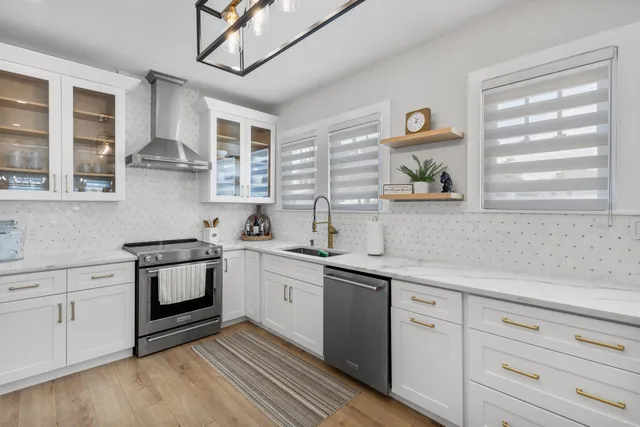 a kitchen with stainless steel appliances white cabinets and a sink