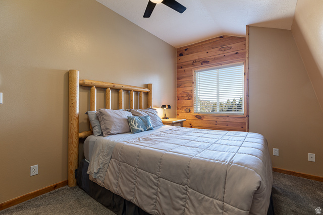 1505 West Elk Ridge Drive Alton, UT 84710 - Photo 25 of 53 Bedroom with vaulted ceiling, carpet flooring, a ceiling fan, and wooden walls