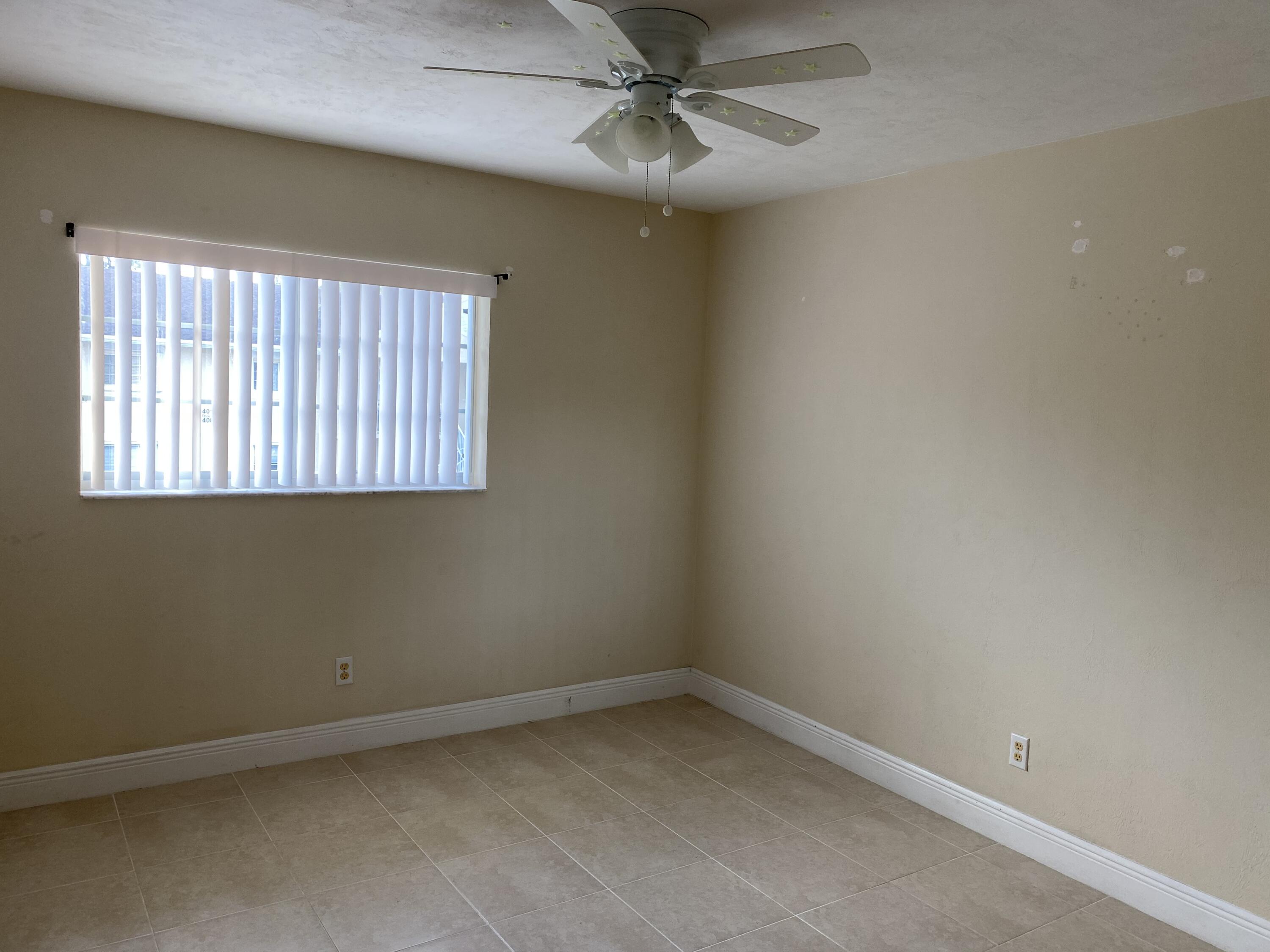 1707 Palm Beach Trace Drive, Unit 1707 Royal Palm Beach, FL 33411 - Photo 7 of 9 an empty room with a window