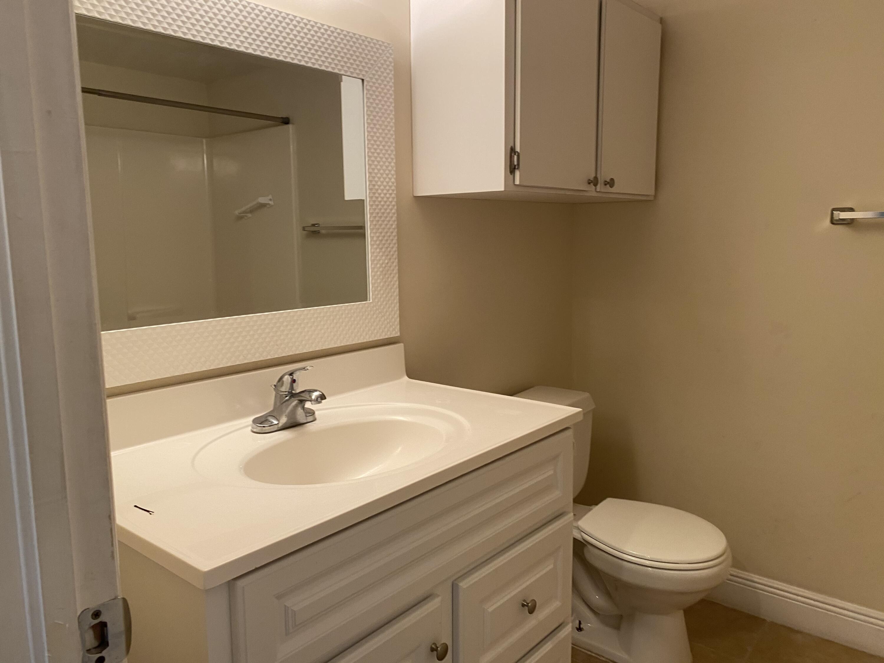1707 Palm Beach Trace Drive, Unit 1707 Royal Palm Beach, FL 33411 - Photo 8 of 9 a bathroom with a sink toilet and vanity