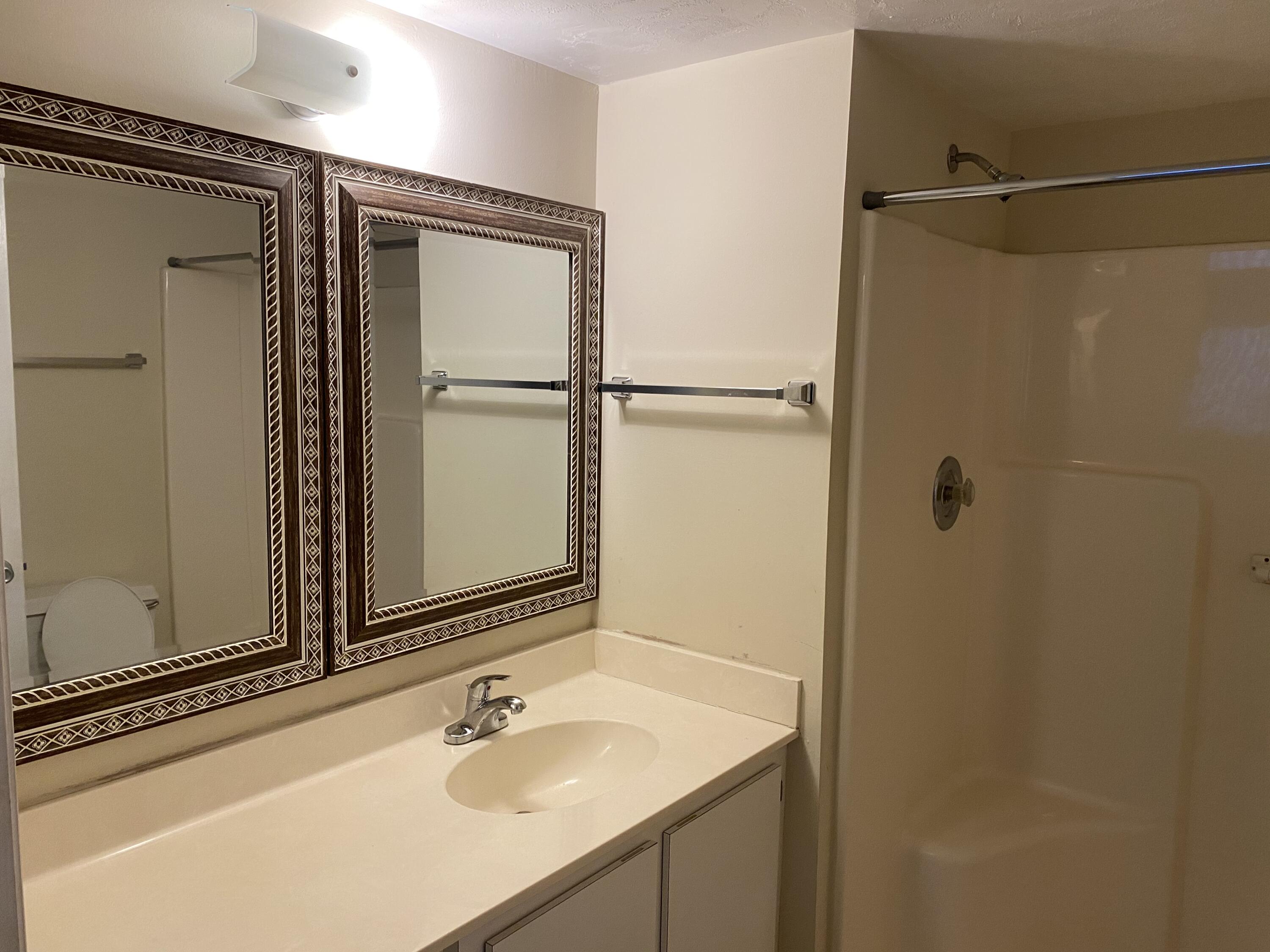 1707 Palm Beach Trace Drive, Unit 1707 Royal Palm Beach, FL 33411 - Photo 9 of 9 a bathroom with a sink and mirror