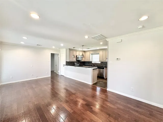 a view of kitchen with kitchen island white cabinets and stainless steel appliances