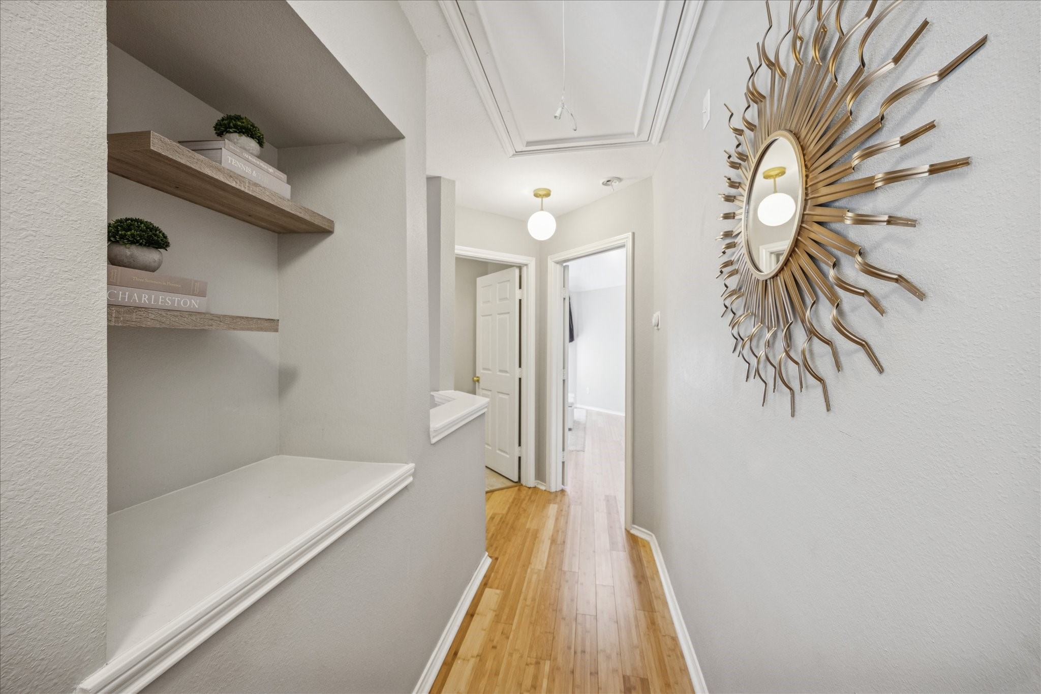 2607 Link Road Houston, TX 77009 - Photo 7 of 21 This hallway features light wood flooring, neutral walls, and built-in shelves. The space is well-lit with modern fixtures, creating an inviting and contemporary atmosphere.