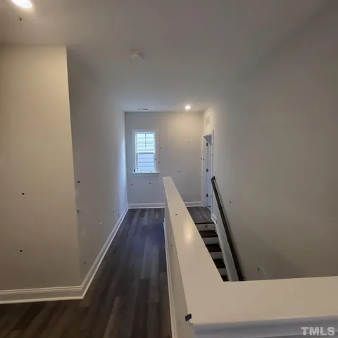an entryway in a hall with wooden floor and windows