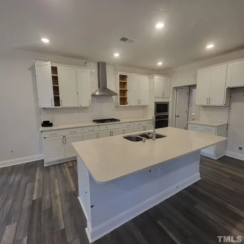a kitchen with kitchen island sink stove and refrigerator