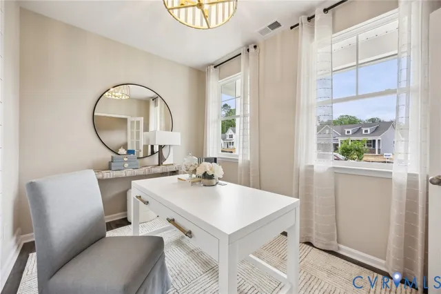 a room with a table chairs and a kitchen view