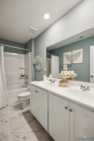 a bathroom with a double vanity sink toilet mirror and bathtub