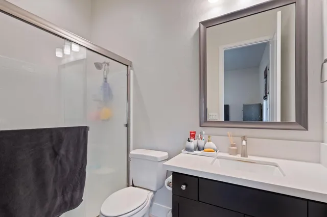 a bathroom with a sink vanity mirror and toilet