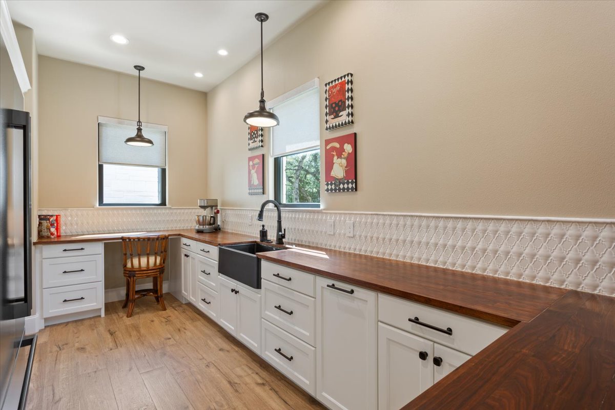 309 Highland Spring Lane Georgetown, TX 78633 - Photo 13 of 40 A true Butler's Pantry just off of the kitchen is so incredibly accommodating & gorgeous. Walnut Butcher Block counters, tile backsplash, another Blanco sink & a desk area highlight this side of the room...
