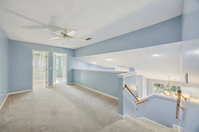an empty room with a window and a ceiling fan