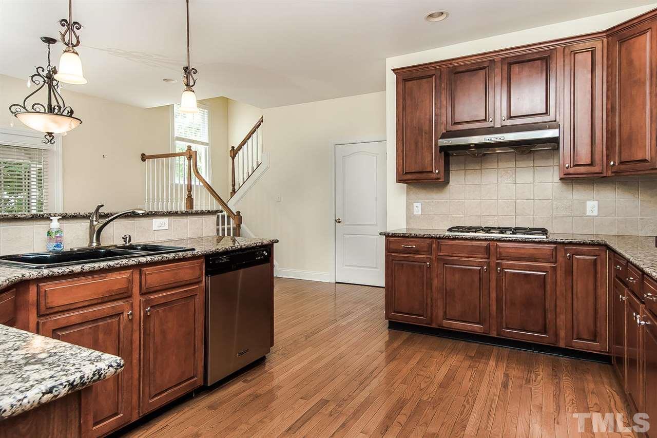 9001 Winged Thistle Court Raleigh, NC 27617 - Photo 1 of 25 a kitchen with stainless steel appliances granite countertop wooden cabinets a refrigerator and a sink
