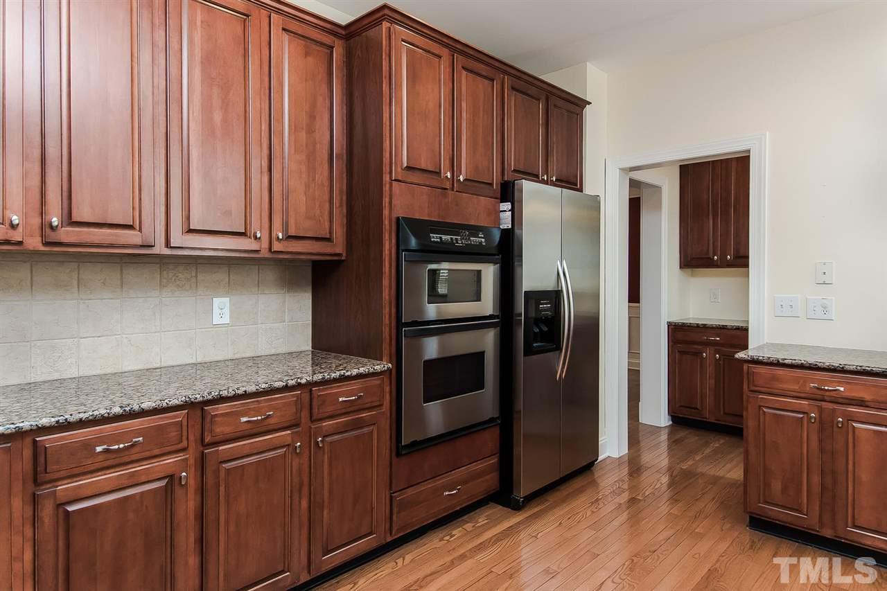 9001 Winged Thistle Court Raleigh, NC 27617 - Photo 2 of 25 a kitchen with stainless steel appliances granite countertop a refrigerator and a stove top oven