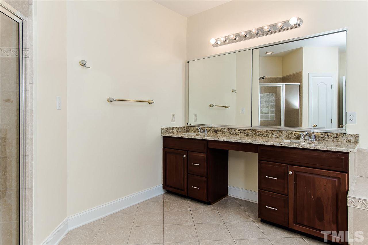 9001 Winged Thistle Court Raleigh, NC 27617 - Photo 11 of 25 a bathroom with a granite countertop sink and a mirror