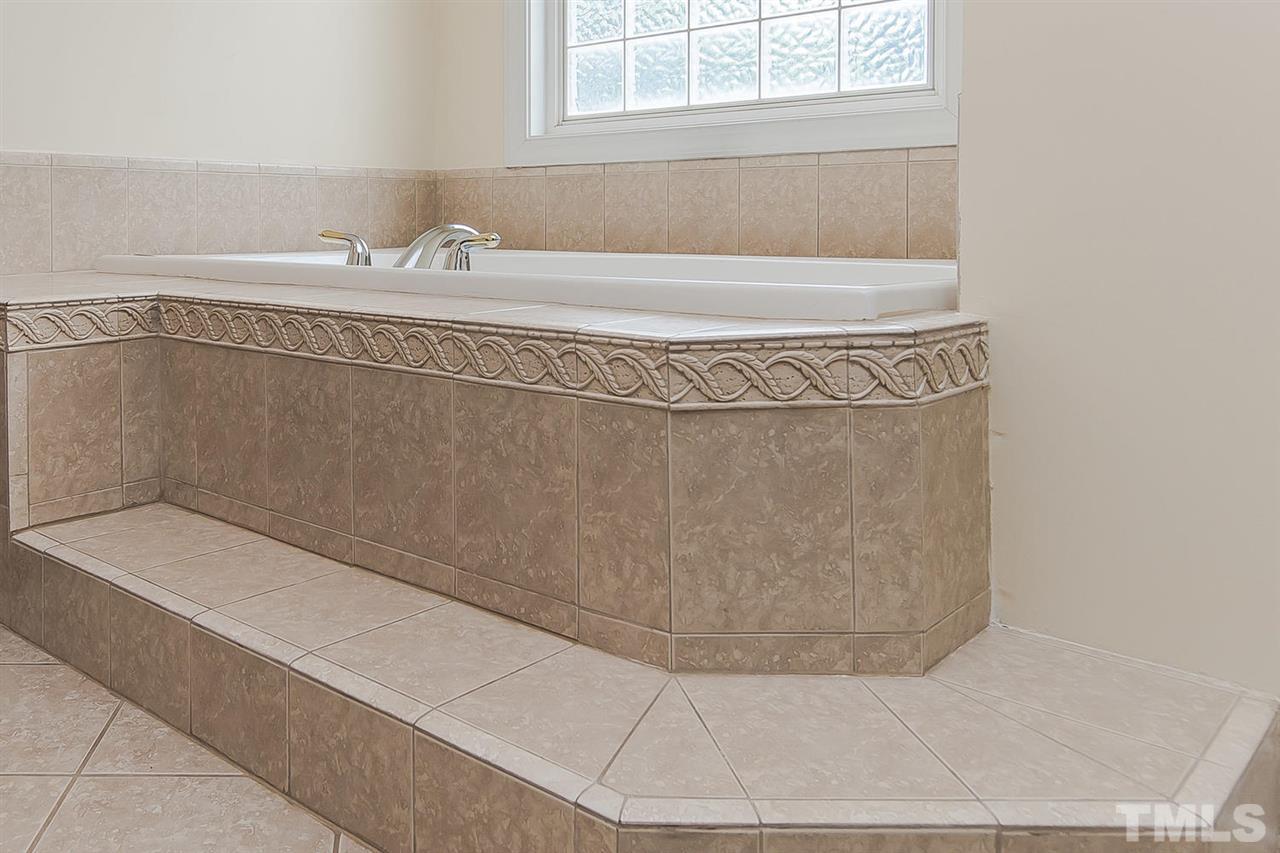 9001 Winged Thistle Court Raleigh, NC 27617 - Photo 12 of 25 a bathroom with a bathtub