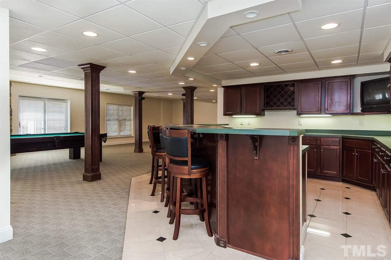 9001 Winged Thistle Court Raleigh, NC 27617 - Photo 18 of 25 a kitchen with stainless steel appliances kitchen island granite countertop a table chairs sink and cabinets