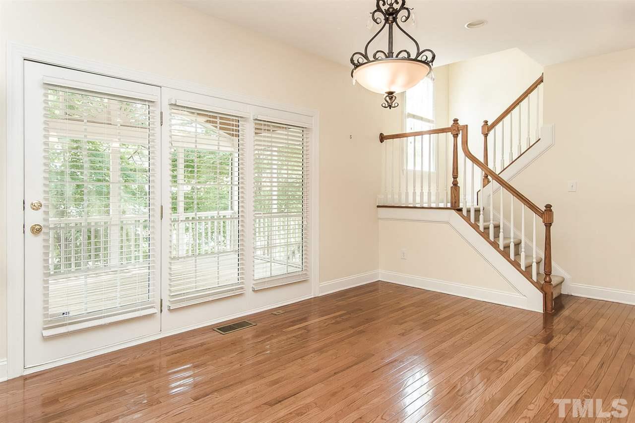 9001 Winged Thistle Court Raleigh, NC 27617 - Photo 5 of 25 a view of an empty room with wooden floor and windows