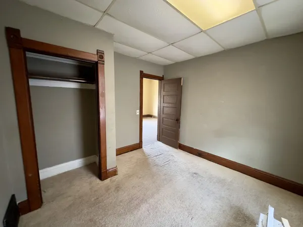 an empty room with closet and wooden door