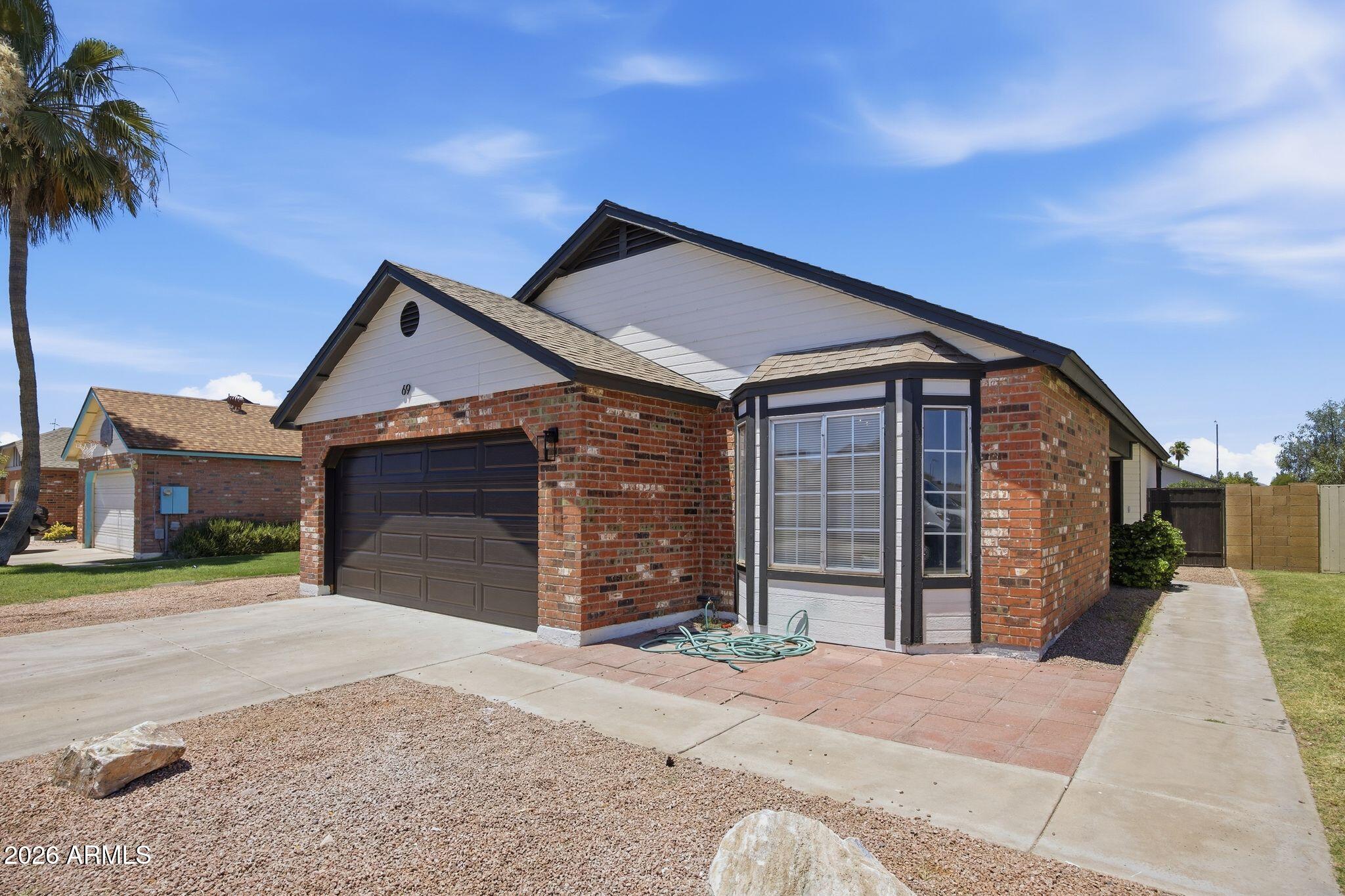 3134 East McKellips Road, Unit 69 Mesa, AZ 85213 - Photo 2 of 24 a front view of a house with a yard and garage
