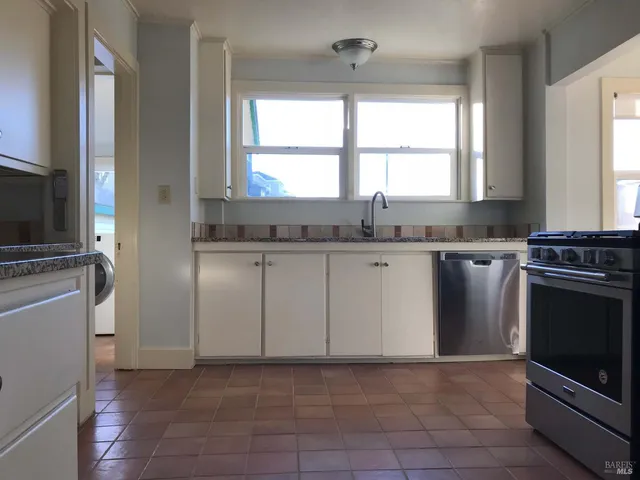 a kitchen with stainless steel appliances granite countertop a stove a sink and a microwave