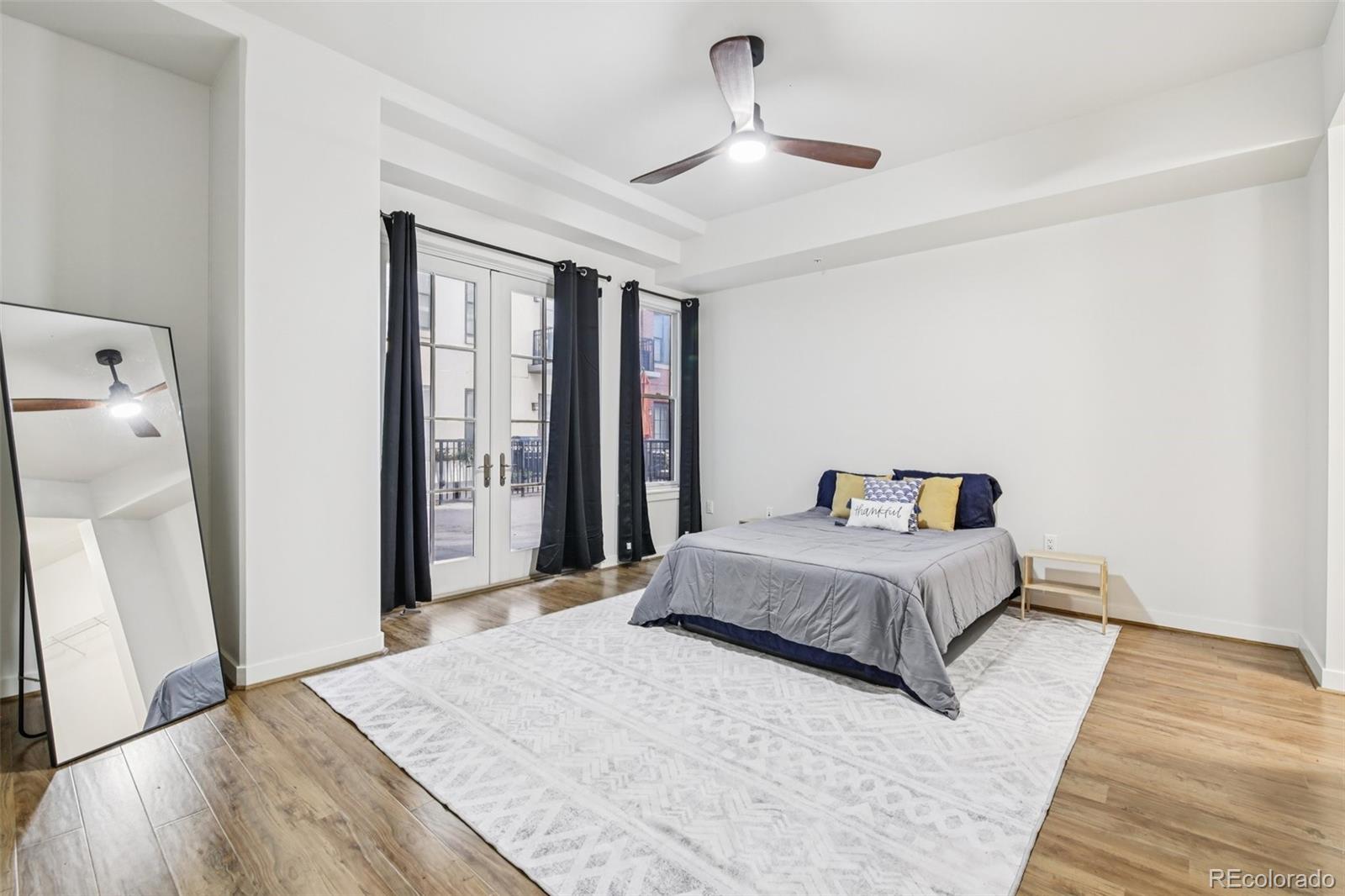 410 Acoma Street, Unit 206 Denver, CO 80204 - Photo 12 of 37 a spacious bedroom with a bed and a large mirror
