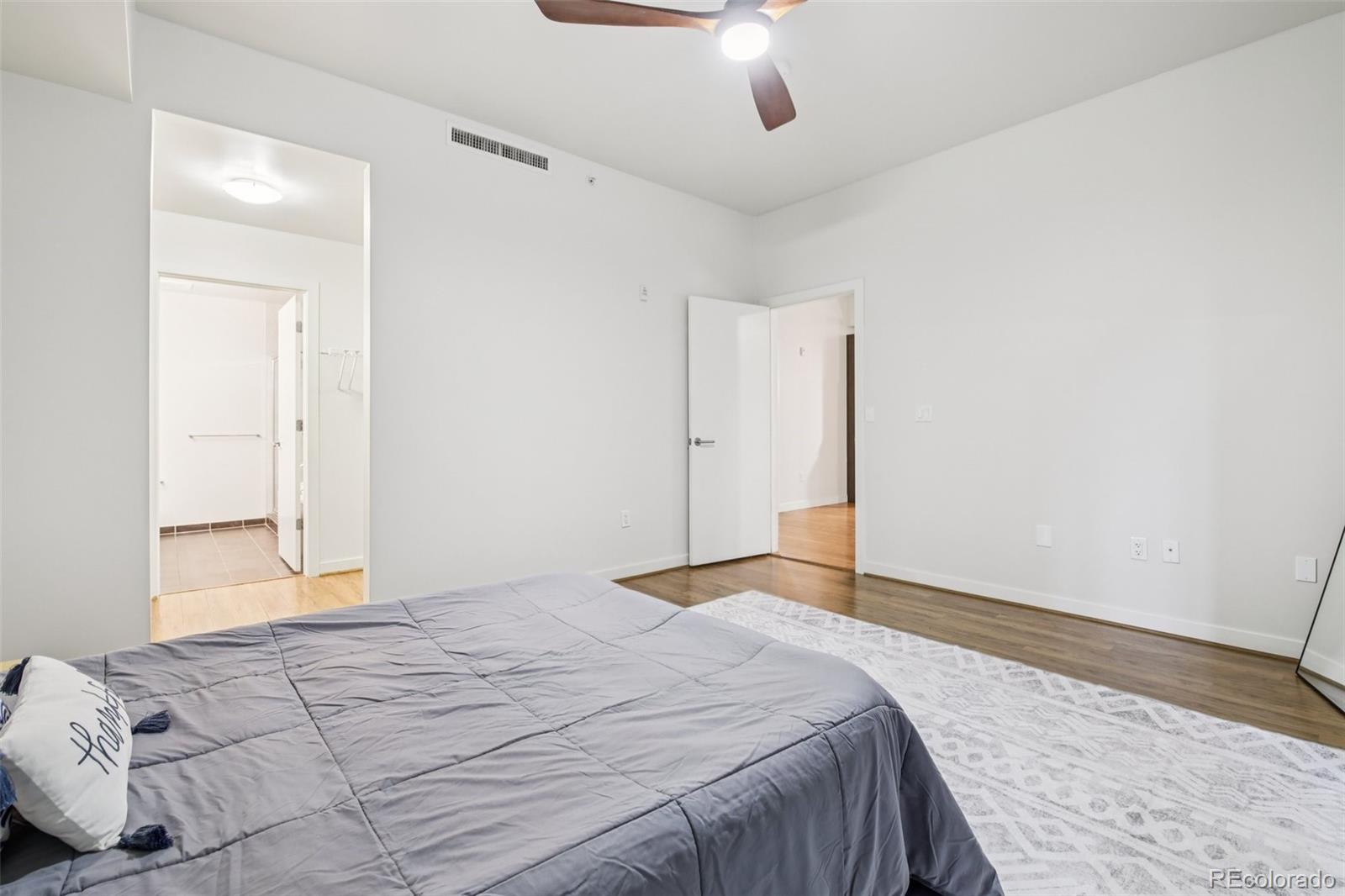 410 Acoma Street, Unit 206 Denver, CO 80204 - Photo 14 of 37 a bedroom with a large bed and a chandelier