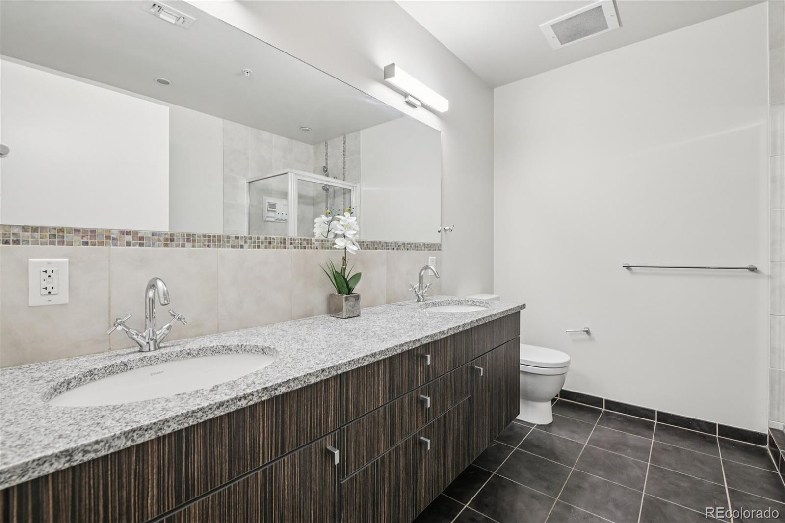 410 Acoma Street, Unit 206 Denver, CO 80204 - Photo 16 of 37 a bathroom with a granite countertop sink and a mirror