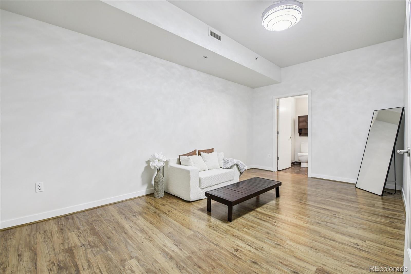 410 Acoma Street, Unit 206 Denver, CO 80204 - Photo 19 of 37 a living room with furniture and a wooden floor