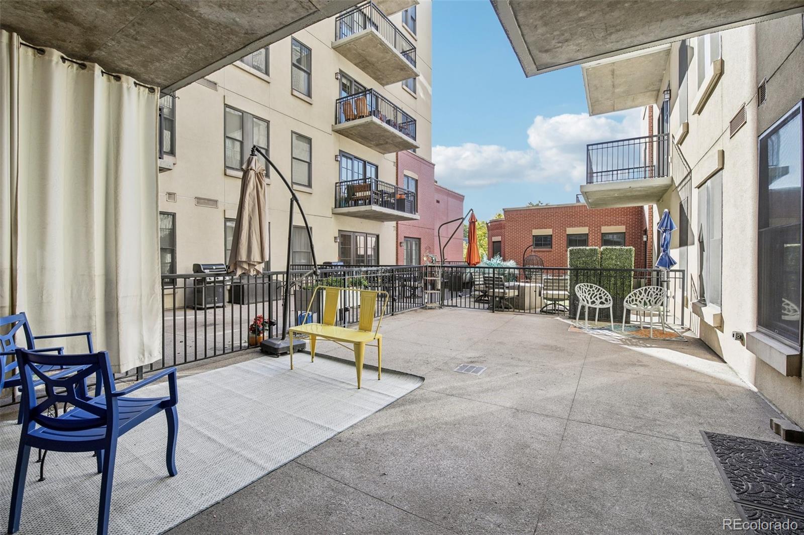 410 Acoma Street, Unit 206 Denver, CO 80204 - Photo 2 of 37 a city view with tall buildings and a bench in patio