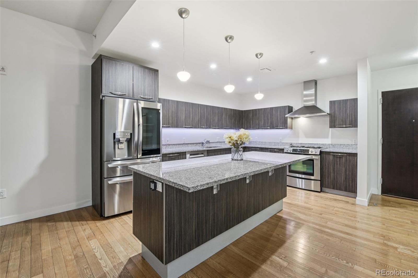 410 Acoma Street, Unit 206 Denver, CO 80204 - Photo 5 of 37 a kitchen with stainless steel appliances granite countertop a sink a stove and a refrigerator