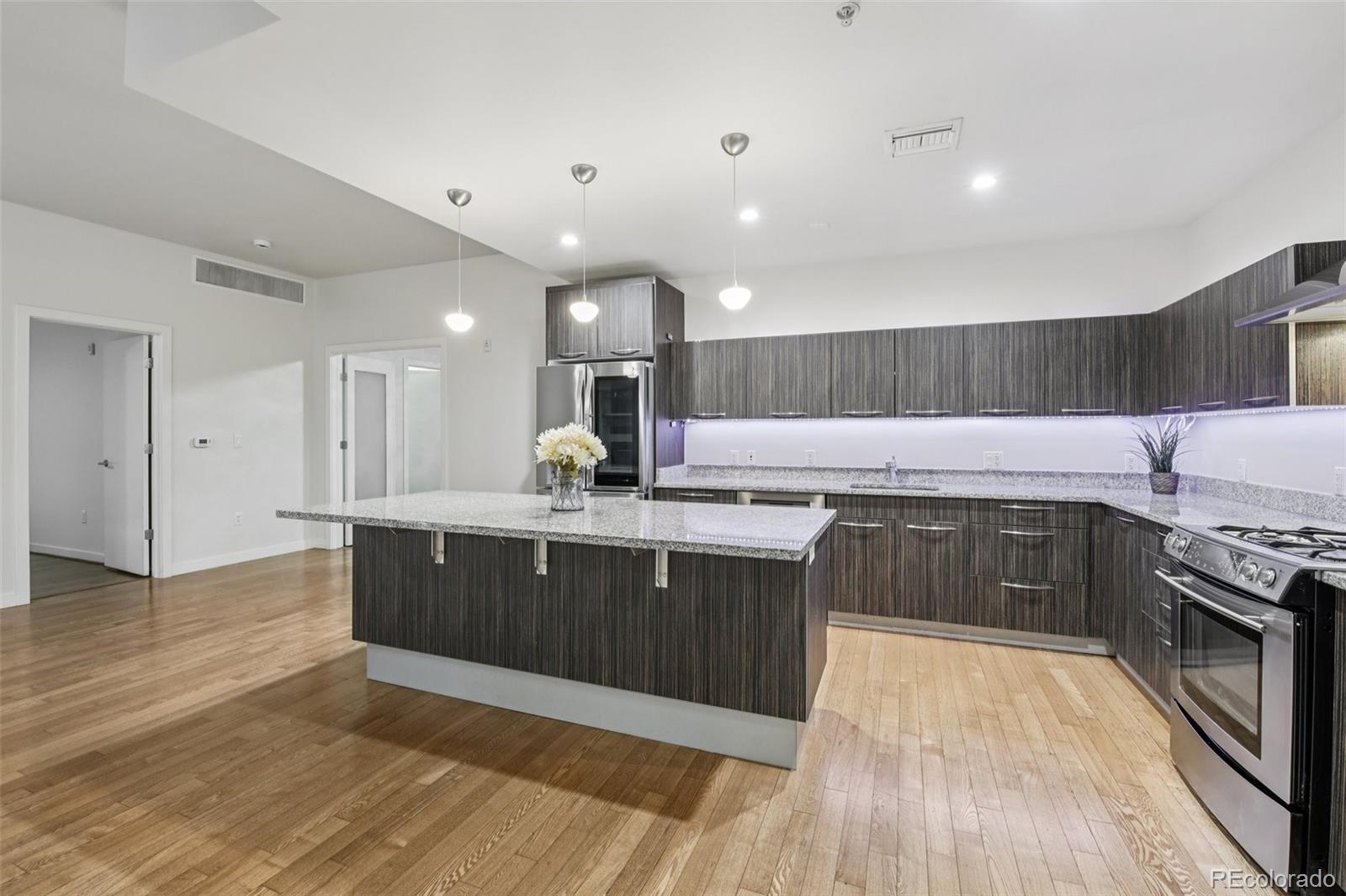 410 Acoma Street, Unit 206 Denver, CO 80204 - Photo 6 of 37 a large kitchen with granite countertop a large counter top space stainless steel appliances and cabinets