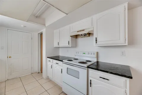 a kitchen with granite countertop white cabinets and white appliances