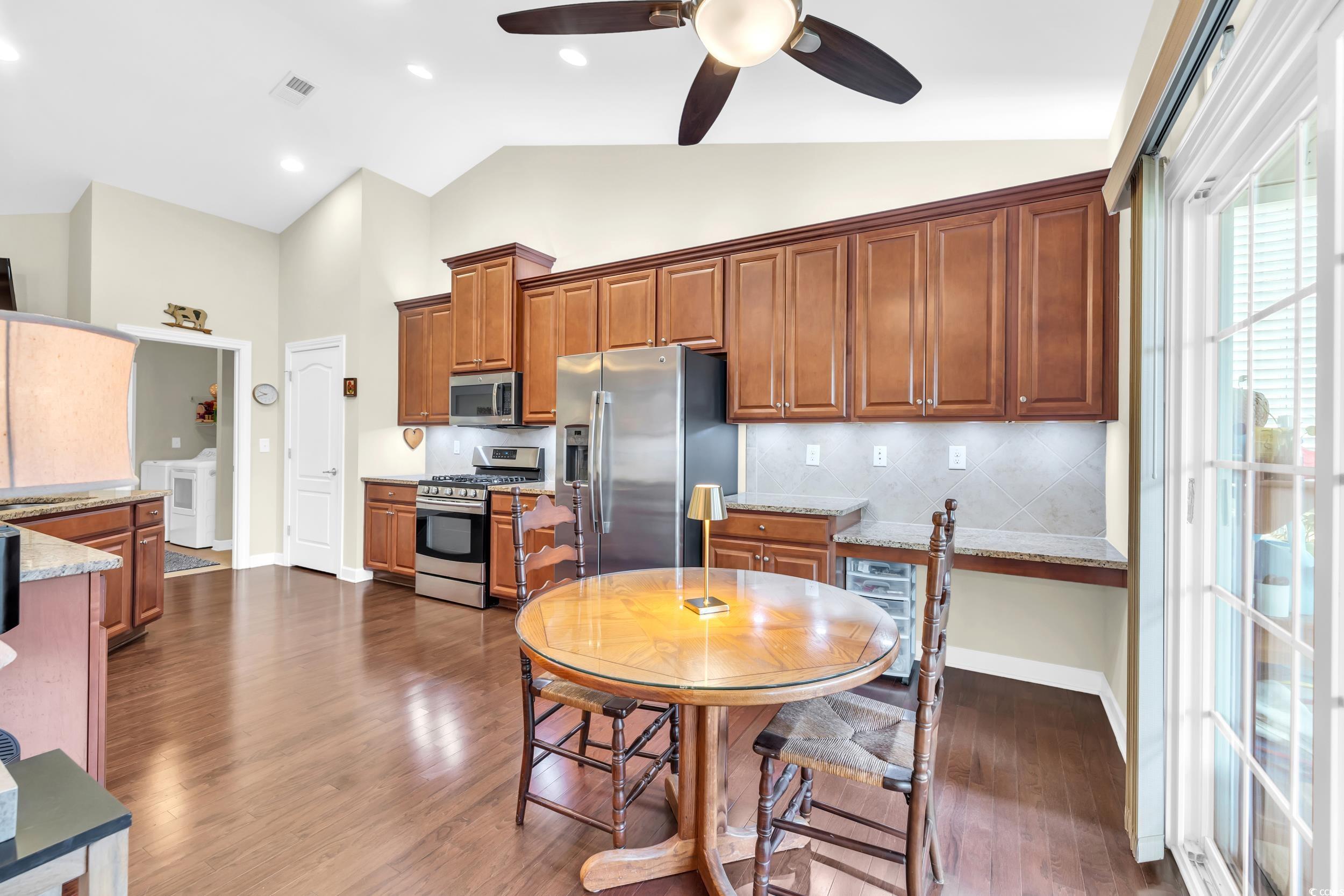1464 Culbertson Avenue Myrtle Beach, SC 29577 - Photo 11 of 40 Kitchen with tasteful backsplash, stainless steel appliances, dark wood-type flooring, light stone counters, and high vaulted ceiling