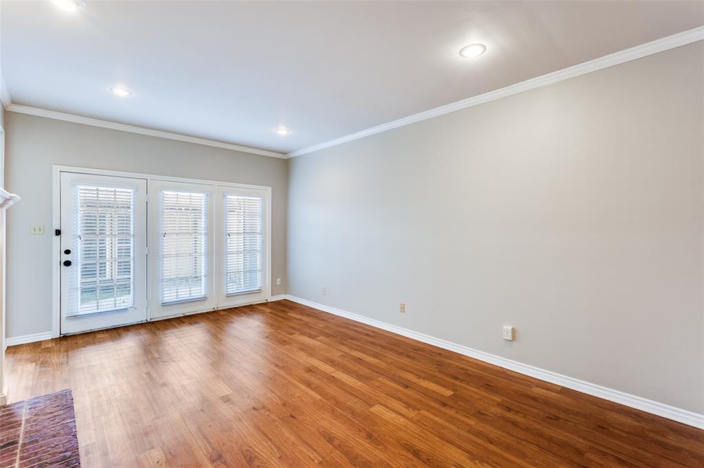 148 Cobblestone Row Denton, TX 76207 - Photo 5 of 33 The living room features canned, recessed lighting, a door to the back yard, and windows on the far wall facing the enclosed back yard.