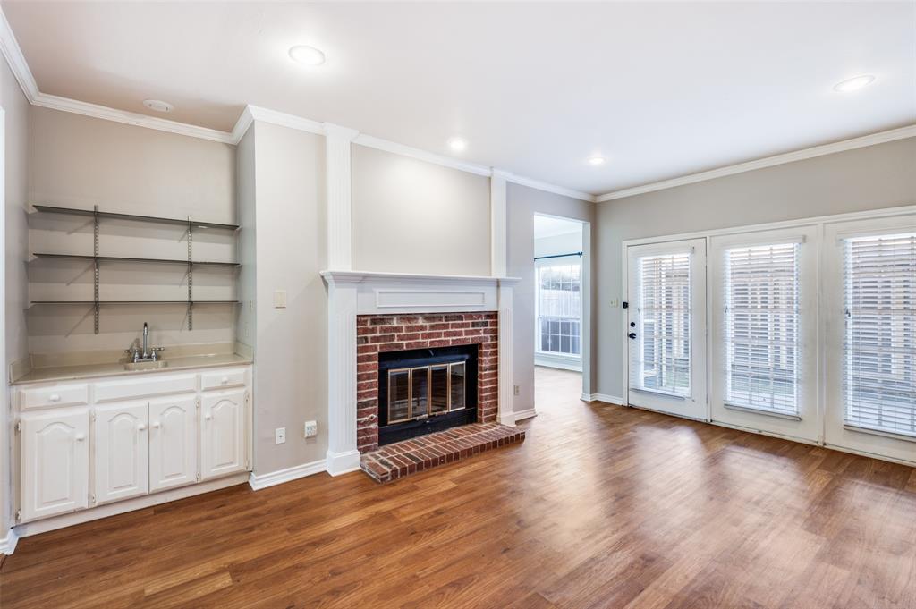 148 Cobblestone Row Denton, TX 76207 - Photo 6 of 33 In addition to the wet bar, the living room also features a beautiful brick fireplace.