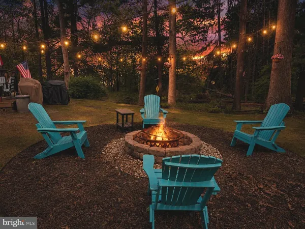 a backyard of a house with fire pit and outdoor seating