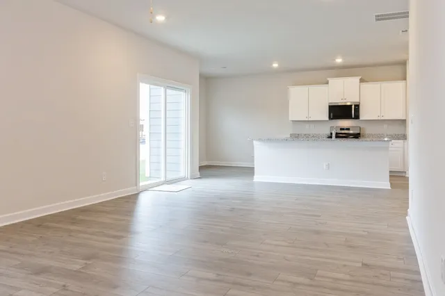 a view of kitchen with wooden floor and electronic appliances