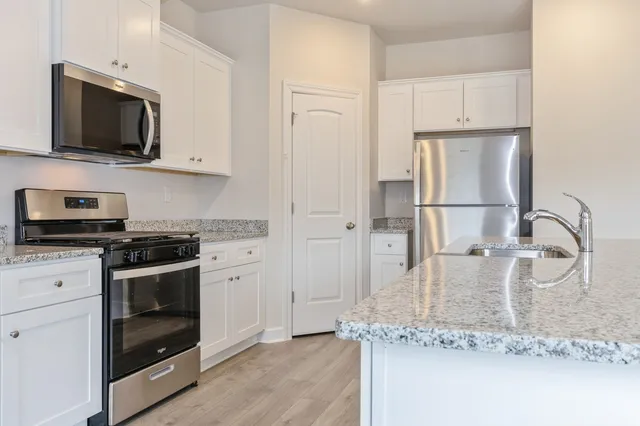 a kitchen with stainless steel appliances granite countertop a stove a microwave and refrigerator