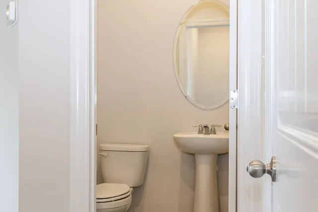 a bathroom with a sink mirror and toilet