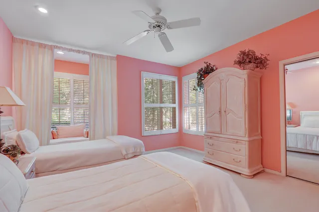 a bedroom with three beds and a chandelier
