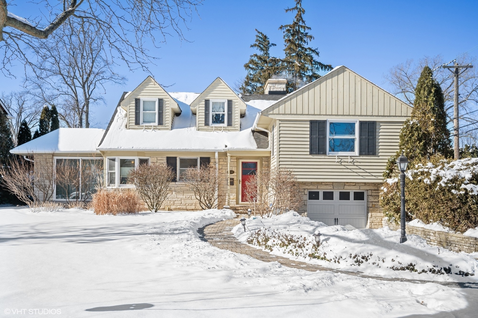 a front view of a house with a yard covered in snow