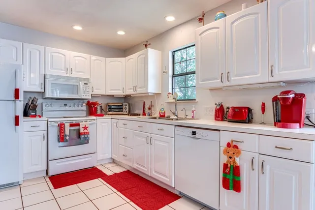 a kitchen with stainless steel appliances kitchen island granite countertop a table chairs and a refrigerator