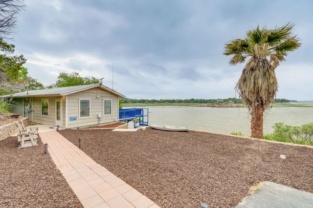 a view of a house with backyard and lake view