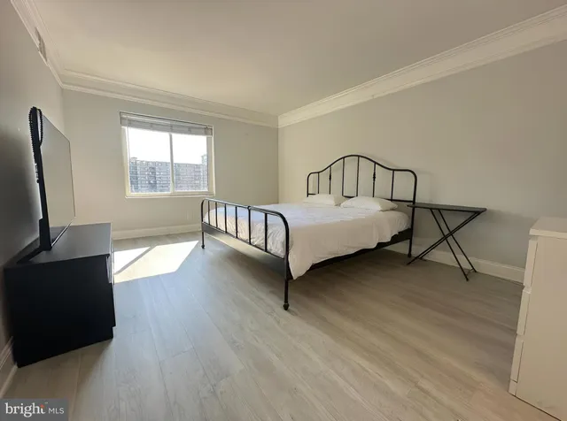 a spacious bedroom with a bed window and a flat screen tv