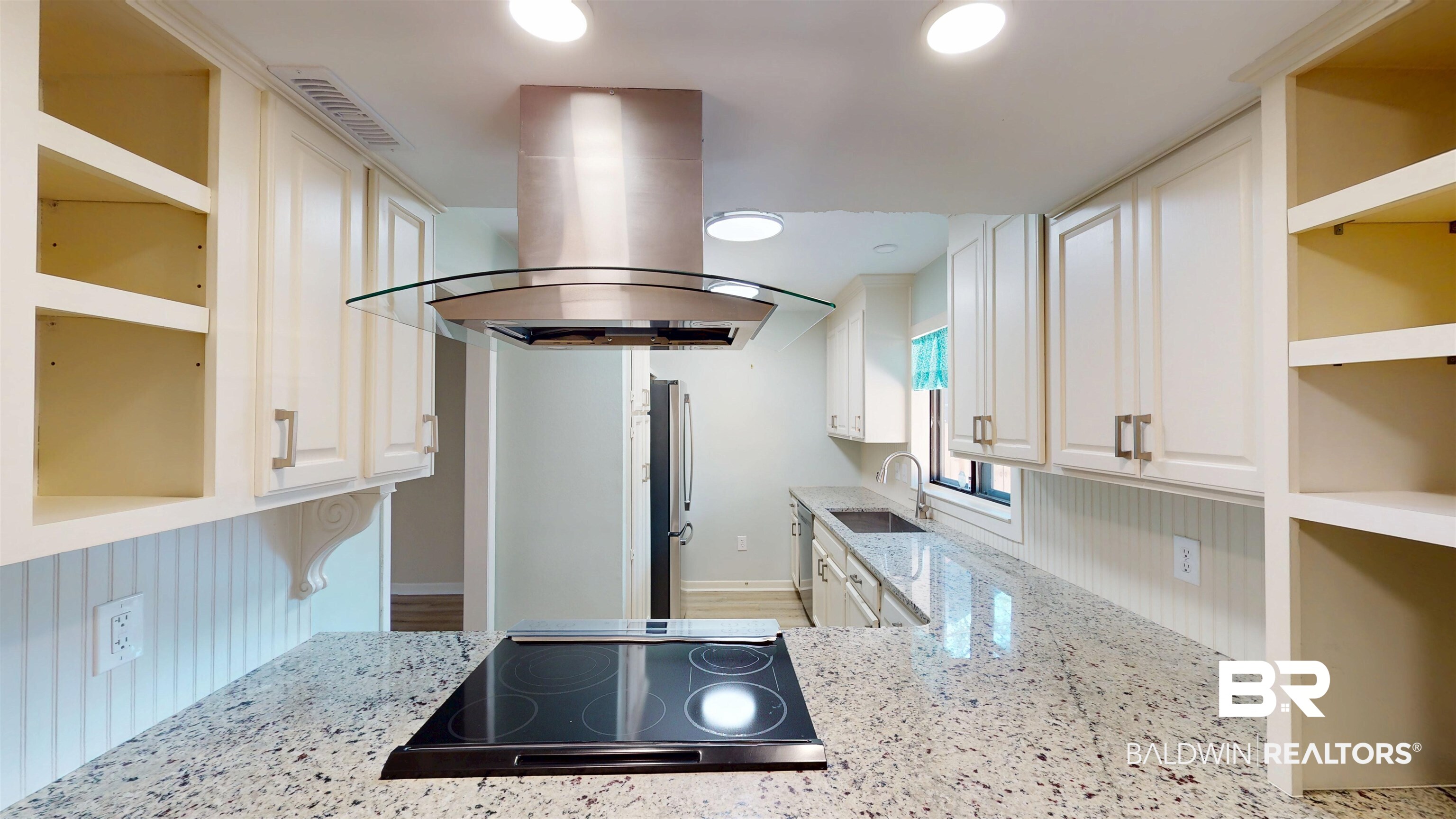2901 Grant Street, Unit 902 Mobile, AL 36606 - Photo 7 of 35 Kitchen with open shelves, light stone counters, island range hood, white cabinets, and recessed lighting
