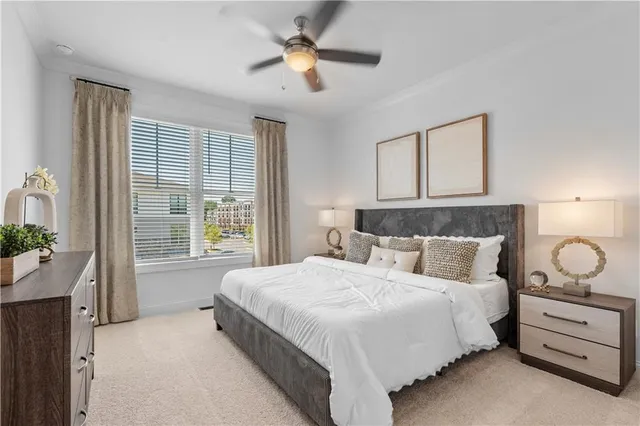 a bedroom with a large bed and a chandelier fan